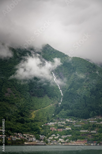 Clouds above Odda town below big waterfall Norway