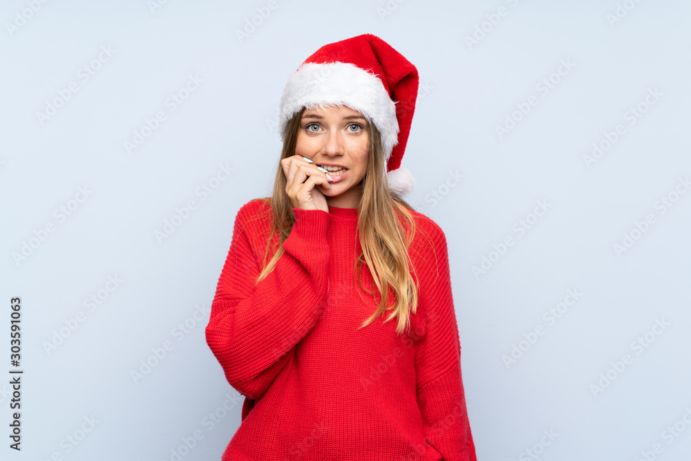 Girl with christmas hat over isolated blue background nervous and scared Girl with christmas hat over isolated blue background nervous and scared