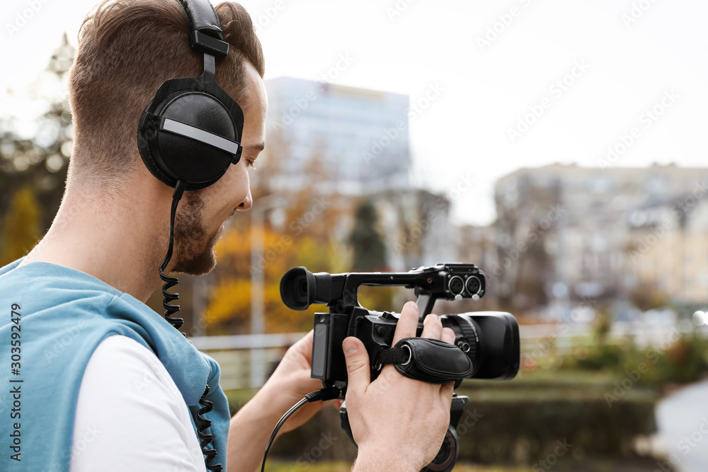 Video operator with professional camera working outdoors