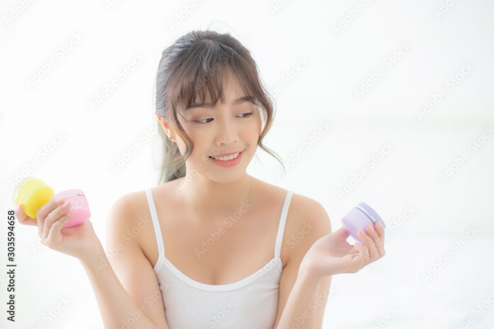 Beautiful portrait young asian woman holding and presenting cream or lotion product, beauty asia girl show cosmetic makeup and moisturizing for skin care, healthy care and wellness concept. Beautiful portrait young asian woman holding and presenting cream or lotion product, beauty asia girl show cosmetic makeup and moisturizing for skin care, healthy care and wellness concept.