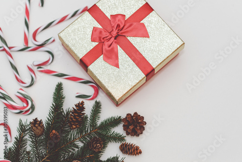 Christmas concept, new year concept. Gift Box, candy staff,candy canes Christmas tree branches. Fir tree branches,close up.Toned.White background.