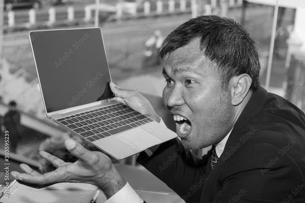 Φωτογραφία An Asian Businessman holds his laptop with his afraid terrified and fears expression feeling at the moment failing shock in the work office room