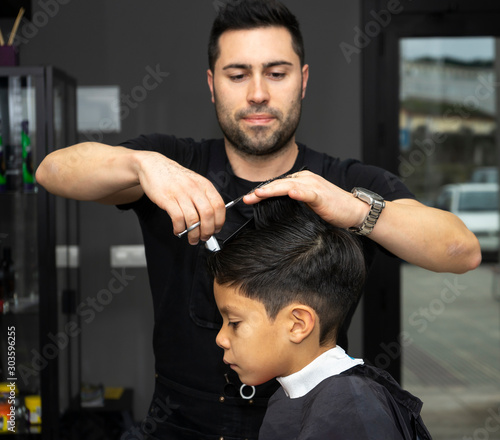 Barber cutting a boy's hair at the barber shop