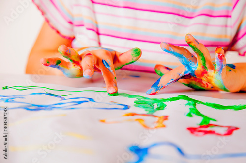 Beautiful child girl painting with colorful  finger. Childhood, art, drawing concept.