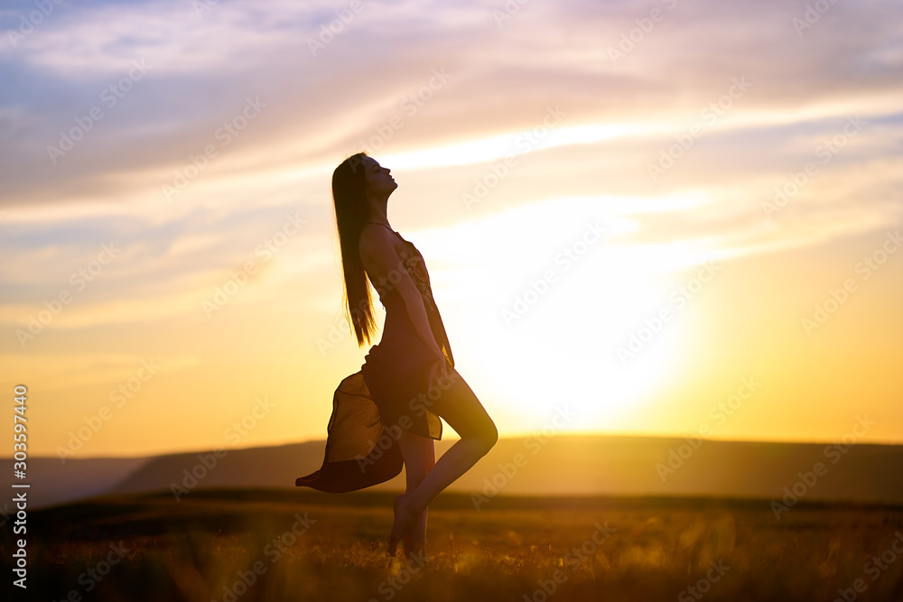 Φωτογραφία Silhouette of a beautiful girl in a light dress at sunset in the mountains