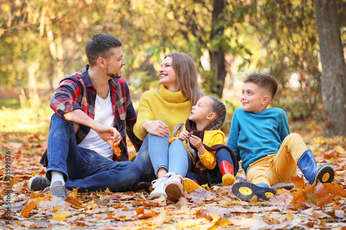Happy family resting in autumn park