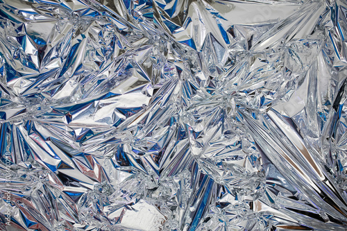 Decoration background of metal crumpled foil, shiny silver surface