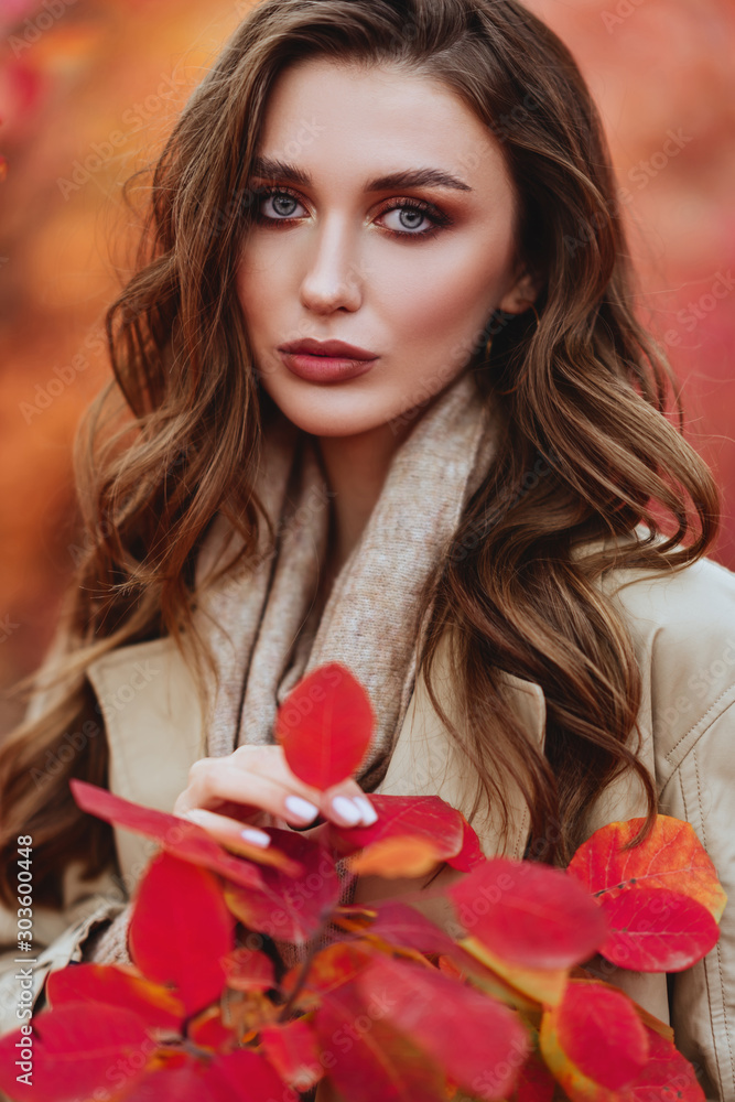 Fashion woman on a background of red and yellow autumn leaves Fashion woman on a background of red and yellow autumn leaves