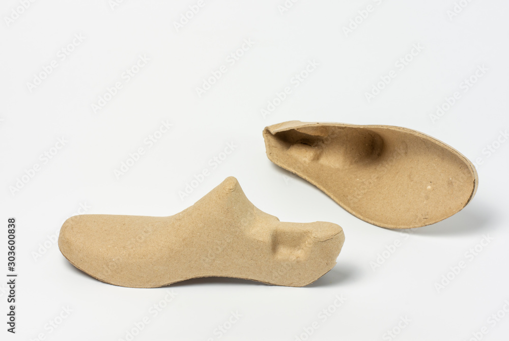 Pair of shoe trees made of recycled paper on white background.