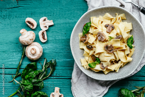 Plate with spaghetti with mushrooms in a creamy sauce on the table