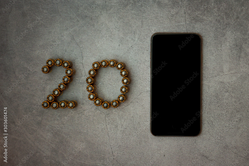 Obraz premium Digit 20 made of bullets. Cartridges from firearms are laid out in the form of numbers 20. Near on the phone you can write any number. New Year and Christmas concept