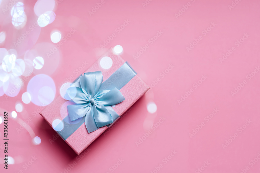 Gift box with Blue ribbon on Pink background for copy space. Christmas minimal concept idea. Gift box with Blue ribbon on Pink background for copy space. Christmas minimal concept idea.