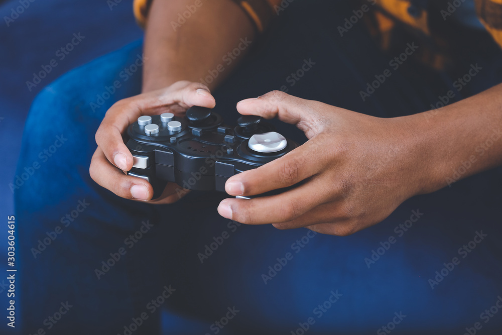 African-American teenager boy playing video games at home, closeup African-American teenager boy playing video games at home, closeup