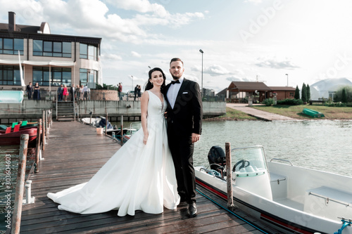 Fototapeta happy bride and groom standing on the pier.