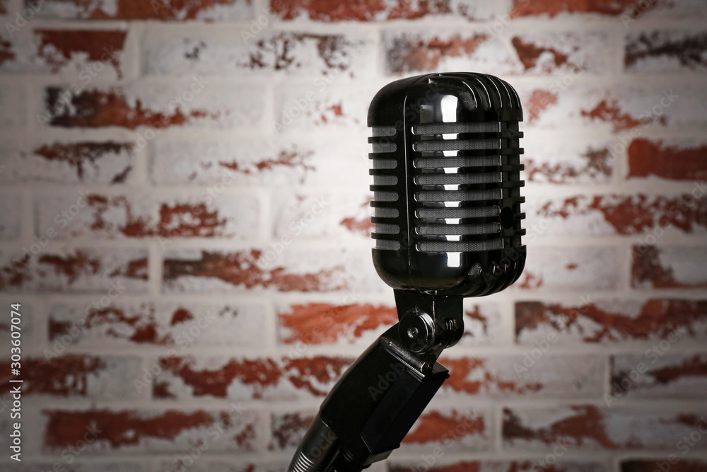 Fototapeta premium Retro microphone on brick background