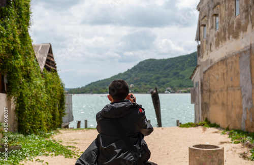 A young man took a photo of landscapes by the sea in the daytime