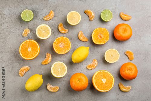 Flat lay composition with tangerines and different citrus fruits on grey background