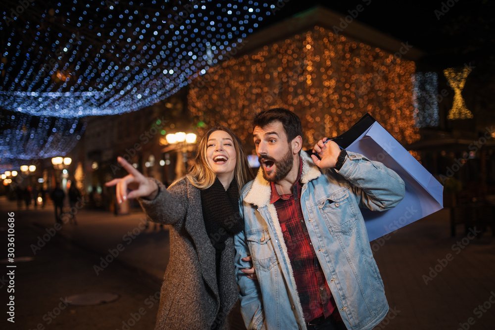 Close up of a young couple shopping in the city at night