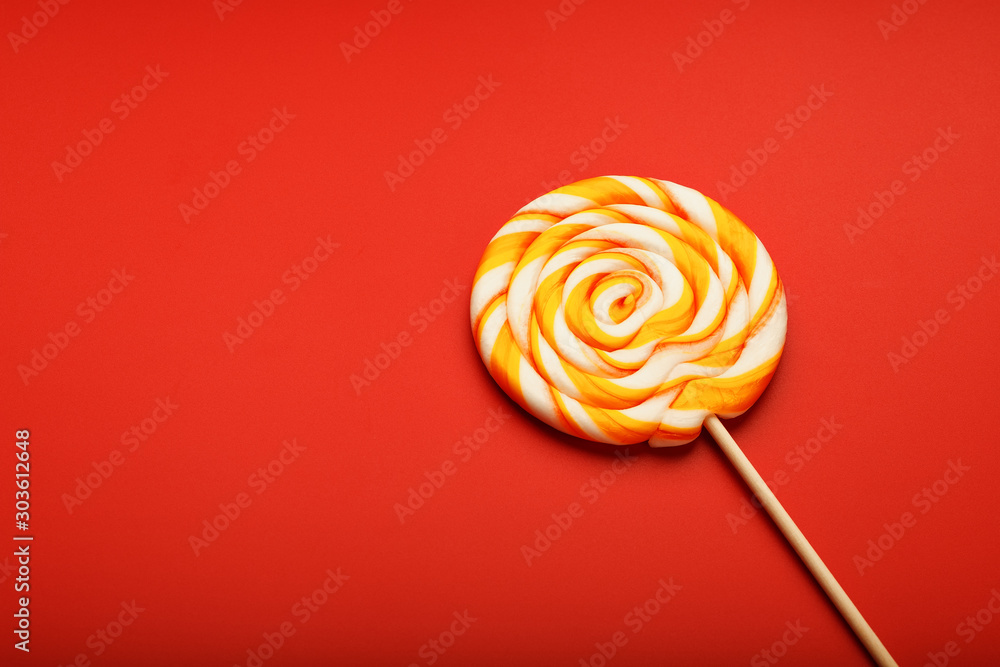 Colorful round Lollipop, on red background. Minimal concept with copy space. Colorful round Lollipop, on red background. Minimal concept with copy space.