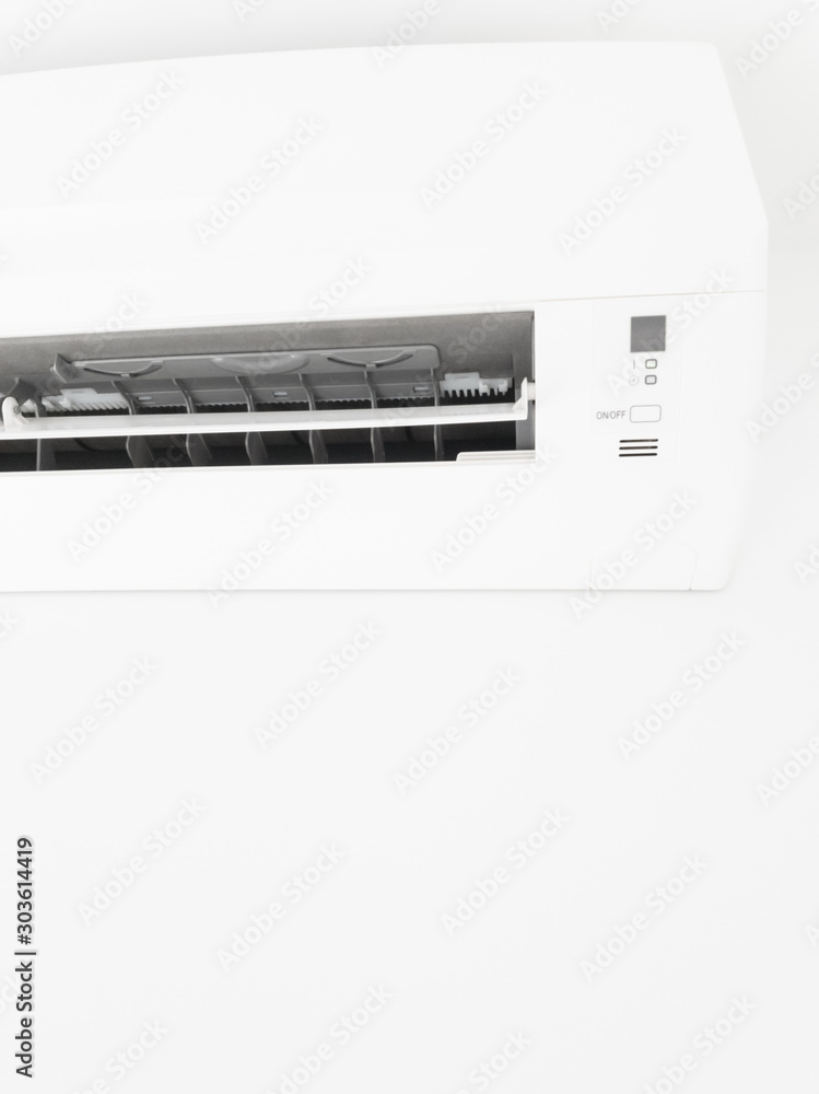 Modern air condition unit on a white wall inside the living room. Modern air condition unit on a white wall inside the living room.