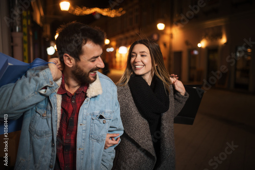 Close up of a young couple shopping in the city at night