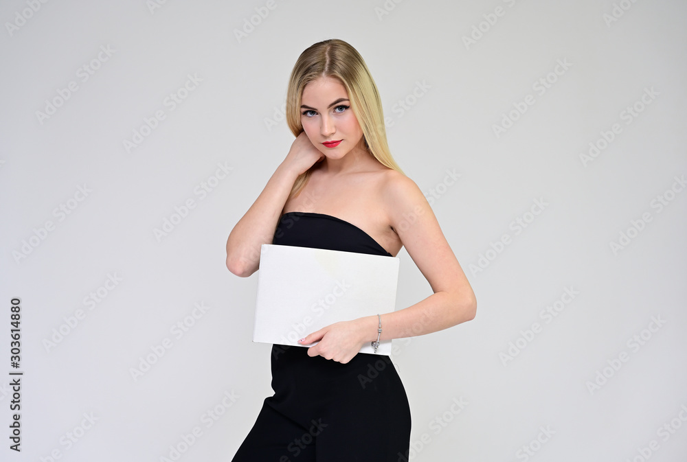 Business training concept with a girl. Portrait of a fashionable beautiful blonde model with long hair, excellent makeup, on a white background with a folder in her hands. Business training concept with a girl. Portrait of a fashionable beautiful blonde model with long hair, excellent makeup, on a white background with a folder in her hands.