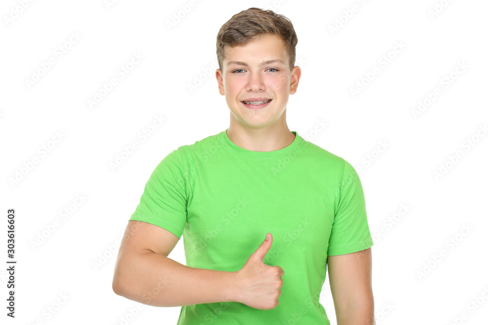 Portrait of young man with dental braces showing thumb up on white background Portrait of young man with dental braces showing thumb up on white background