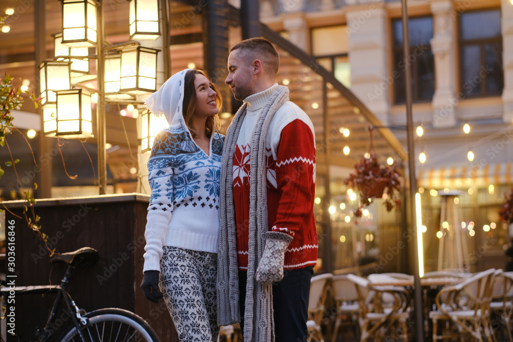 Lovely couple feels happy on the Christmas market, surrounded with warm lights. Lovely couple feels happy on the Christmas market, surrounded with warm lights.