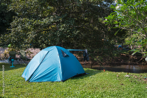Blue tent camping on lawn in tropical rainforest