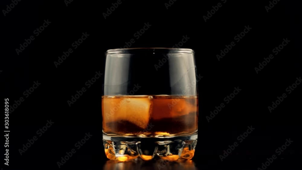 Whiskey Pouring In Glass.Cognac In Glass Floats In Slow Motion.Bourbon Or Rum Pouring In Slow Motion.Running Brandy In Glass From Bottle.Rum Flowing From Brown Bottle. Whiskey Pouring In Glass.Cognac In Glass Floats In Slow Motion.Bourbon Or Rum Pouring In Slow Motion.Running Brandy In Glass From Bottle.Rum Flowing From Brown Bottle.