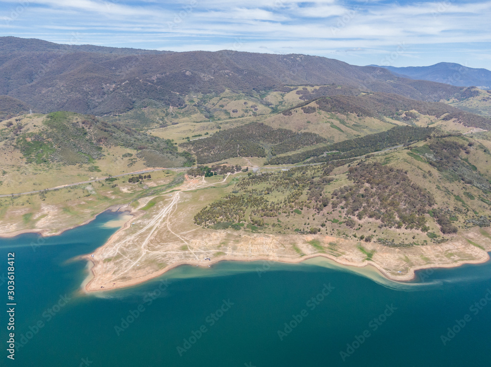 High angle aerial drone view of Blowering Reservoir (dam) near Tumut in the Snowy Mountains region of New South Wales, Australia. Notice the low water levels due to ongoing drought in Australia.
