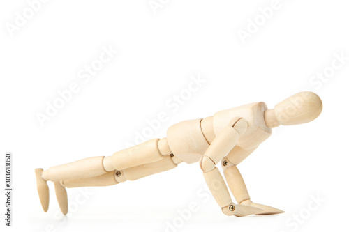 Wooden figure doing exercises on white background