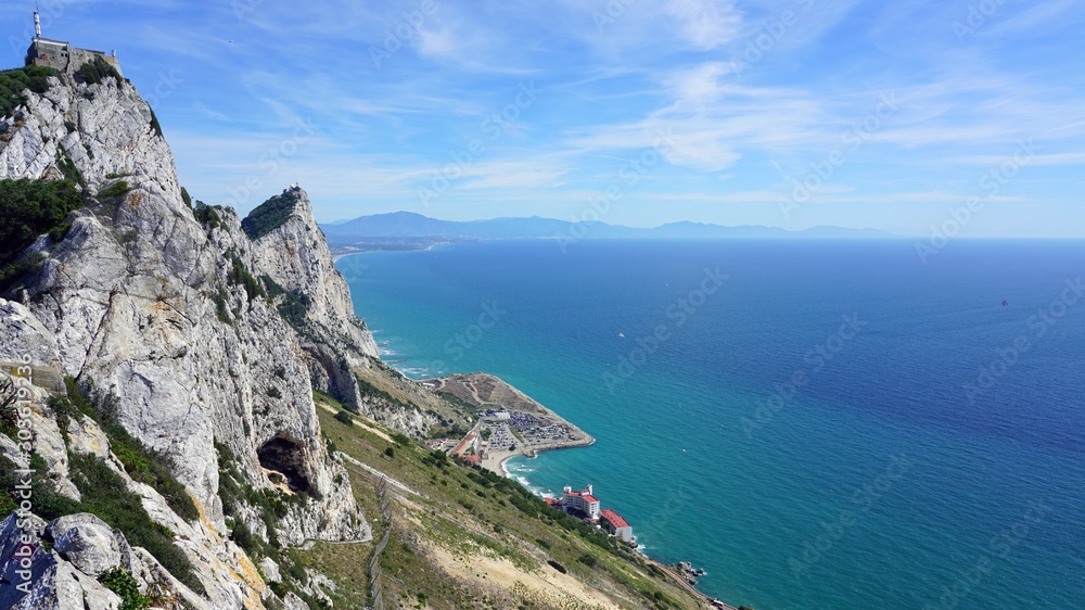 View of the Rock of Gibraltar, a British Overseas Territory on the South coast of Spain where the Mediterranean Sea meets the Atlantic Ocean View of the Rock of Gibraltar, a British Overseas Territory on the South coast of Spain where the Mediterranean Sea meets the Atlantic Ocean