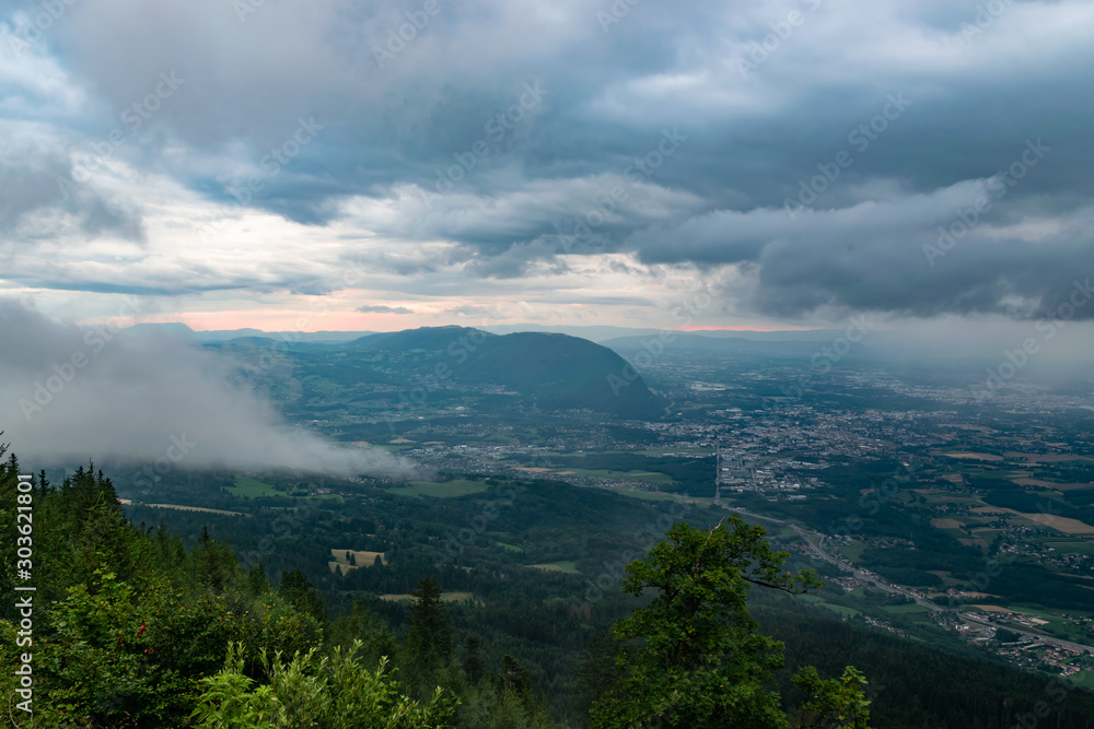Landscape view from the Le Signal des Voirons viewpoint, view of dark low clouds and rain over the city of Geneva.Department Haute-Savoie in France.