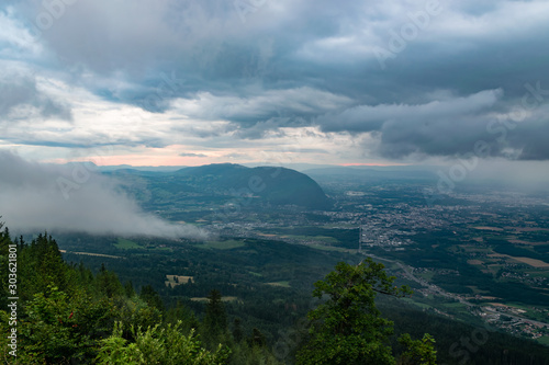 Landscape view from the Le Signal des Voirons viewpoint, view of dark low clouds and rain over the city of Geneva.Department Haute-Savoie in France.