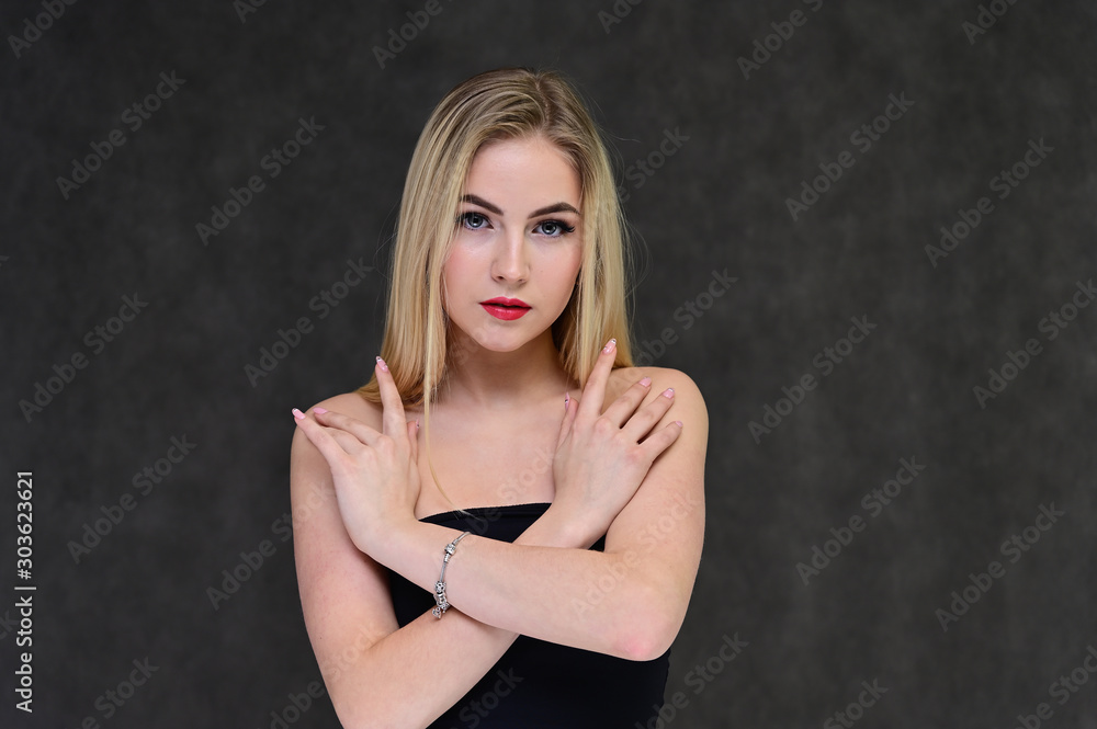The concept of fashionable glamor, cosmetics and beauty with a pretty girl. Portrait of a fashionable beautiful blonde model with long hair, great makeup, on a gray background. The concept of fashionable glamor, cosmetics and beauty with a pretty girl. Portrait of a fashionable beautiful blonde model with long hair, great makeup, on a gray background.
