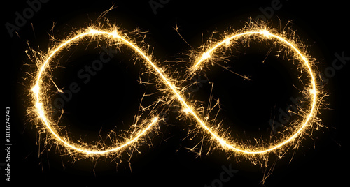 Sparkler sign infinity . Glowing lettering sign made by sparkler. Isolated on a black background .