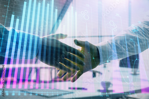 Multi exposure of financial graph on office background with two businessmen handshake. Concept of success in business © Andrey