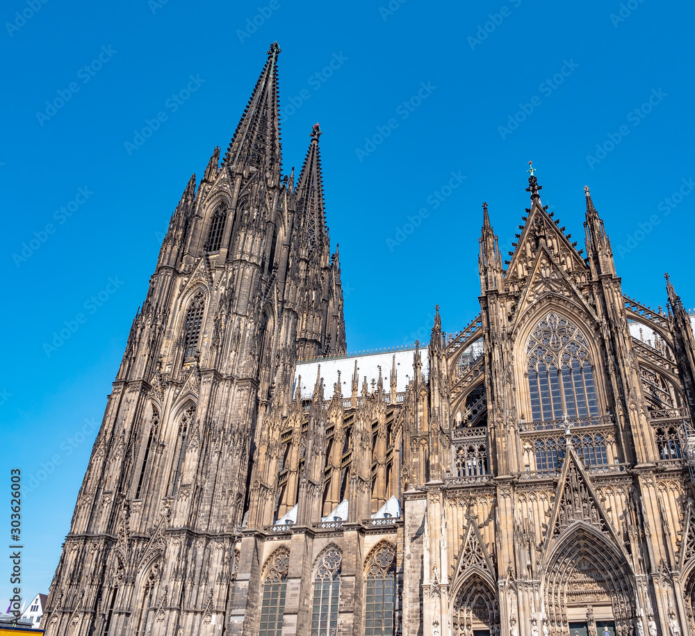 Gothic Cathedral Church of Saint Peter in Cologne, Germany on a sunny day. Beautiful cityscape with details of the towers, arches and windows stained glass Gothic Cathedral Church of Saint Peter in Cologne, Germany on a sunny day. Beautiful cityscape with details of the towers, arches and windows stained glass