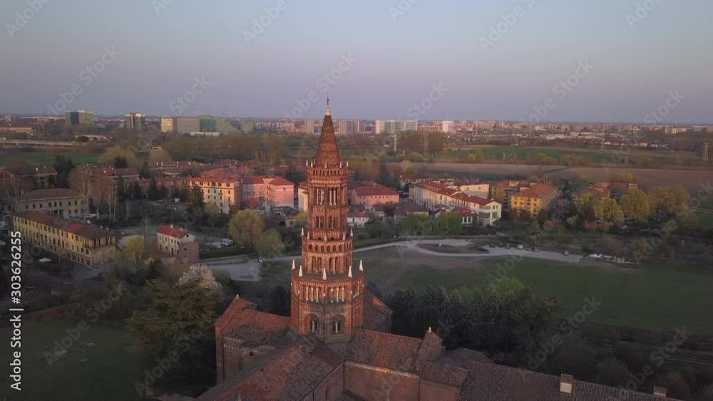 4k aerial drone orbit footage at sunset time to the summit of Chiaravalle abbey, the ancien and prestigious italian monument located  in the south of Milan city.