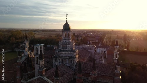 4k aerial drone orbit footage at sunset time of abbey of Pavia, ancien and prestigious italian monument. photo