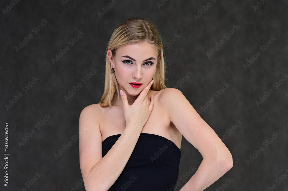 The concept of fashionable glamor, cosmetics and beauty with a pretty girl. Portrait of a fashionable beautiful blonde model with long hair, great makeup, on a gray background. The concept of fashionable glamor, cosmetics and beauty with a pretty girl. Portrait of a fashionable beautiful blonde model with long hair, great makeup, on a gray background.