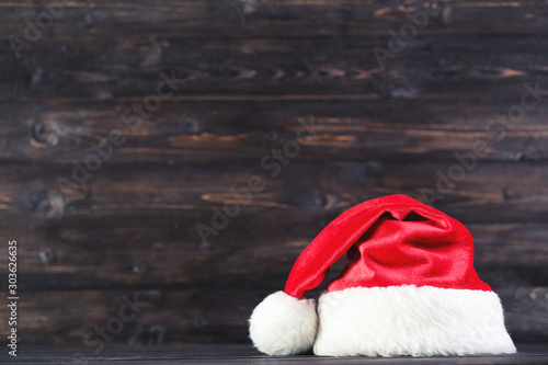 Red santa hat on brown wooden background