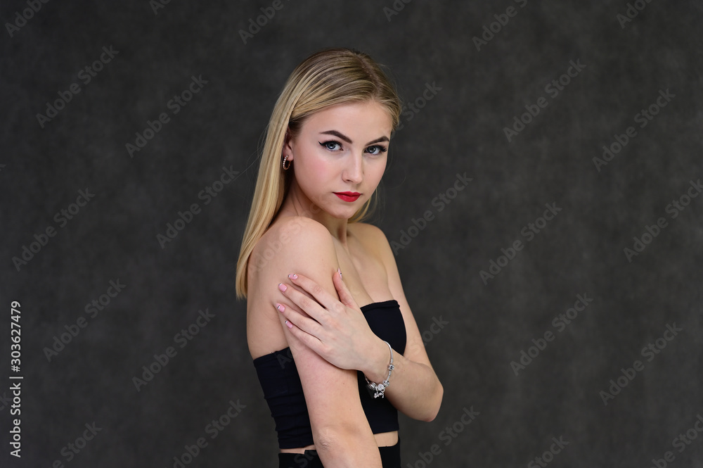 The concept of fashionable glamor, cosmetics and beauty with a pretty girl. Portrait of a fashionable beautiful blonde model with long hair, great makeup, on a gray background. The concept of fashionable glamor, cosmetics and beauty with a pretty girl. Portrait of a fashionable beautiful blonde model with long hair, great makeup, on a gray background.
