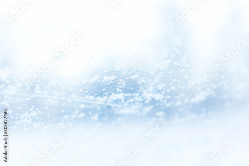 Hoarfrost snowflakes on glass in winter background selective focus