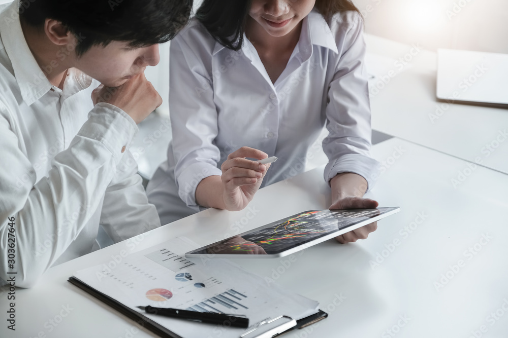 Φωτογραφία Businessman and business woman discuss to working with using tablet and for searching information stock market chart for trading to Make a profit
