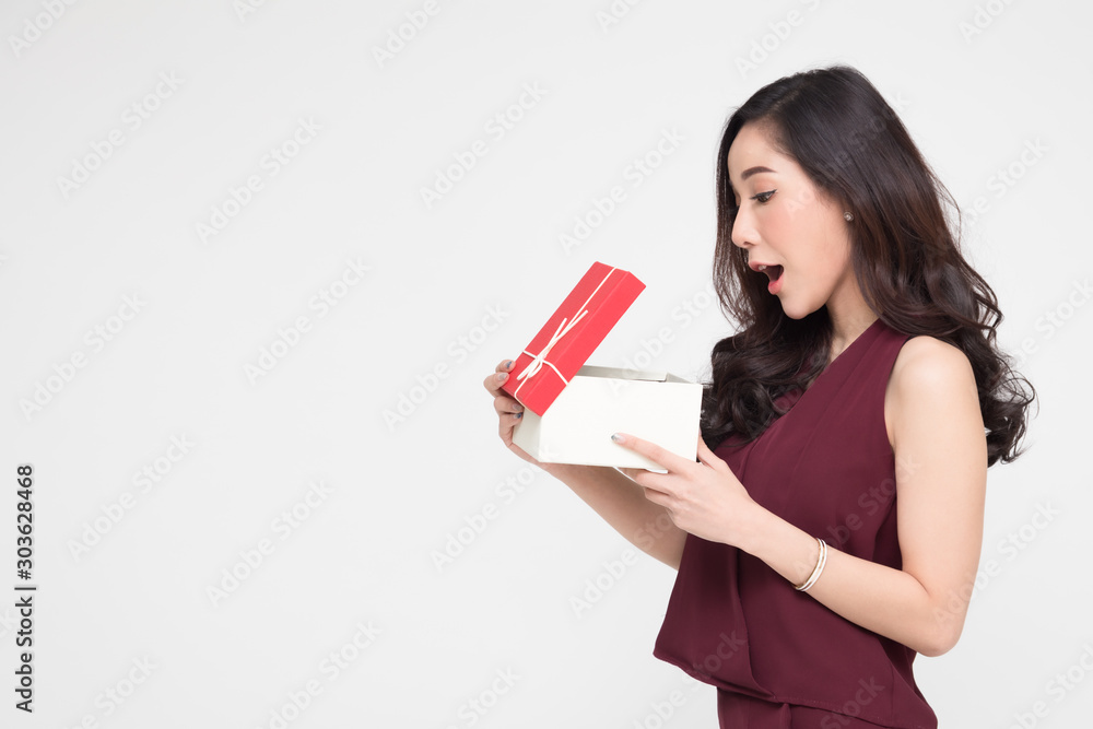 Asian woman holding and showing red gift box and open the box with wow surprise expression isolated on white background Asian woman holding and showing red gift box and open the box with wow surprise expression isolated on white background