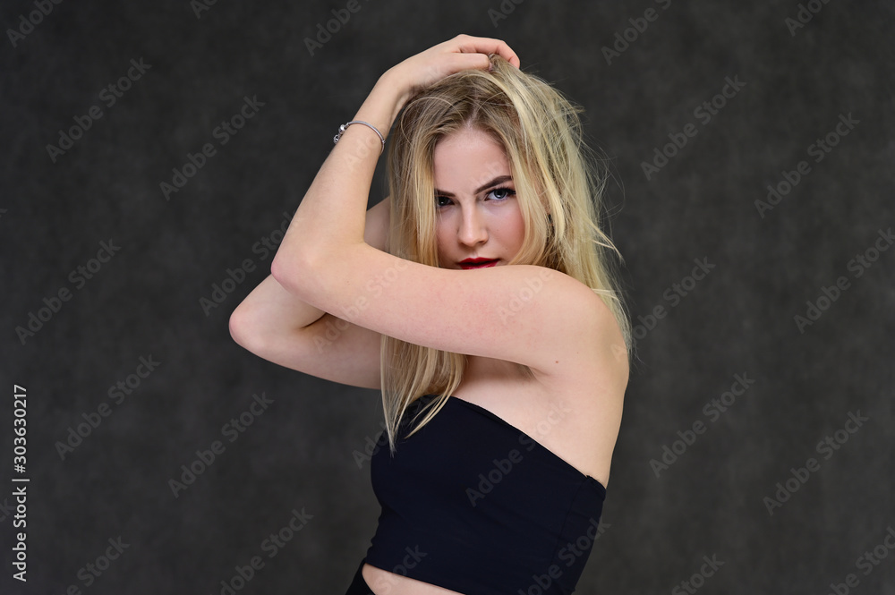 The concept of fashionable glamor, cosmetics and beauty with a pretty girl. Portrait of a fashionable beautiful blonde model with long hair, great makeup, on a gray background. The concept of fashionable glamor, cosmetics and beauty with a pretty girl. Portrait of a fashionable beautiful blonde model with long hair, great makeup, on a gray background.