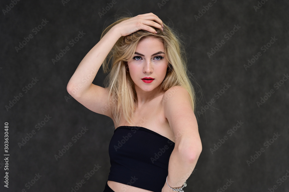 The concept of fashionable glamor, cosmetics and beauty with a pretty girl. Portrait of a fashionable beautiful blonde model with long hair, great makeup, on a gray background. The concept of fashionable glamor, cosmetics and beauty with a pretty girl. Portrait of a fashionable beautiful blonde model with long hair, great makeup, on a gray background.