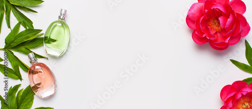 Fototapeta Naklejka Na Ścianę i Meble -  Perfume bottles and pink flowers peonies on light gray background top view Flat lay copy space. Perfumery, cosmetics, female accessories, fragrance collection. Delicate Perfume Bottle